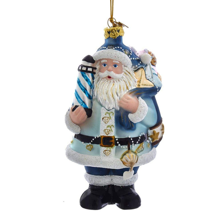 Kurt Adler Noble Gems Nautical Santa glass ornament holding a lighthouse with seashell garland and blue glitter suit
